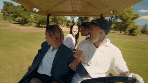 a group of people are riding a golf cart on a golf course
