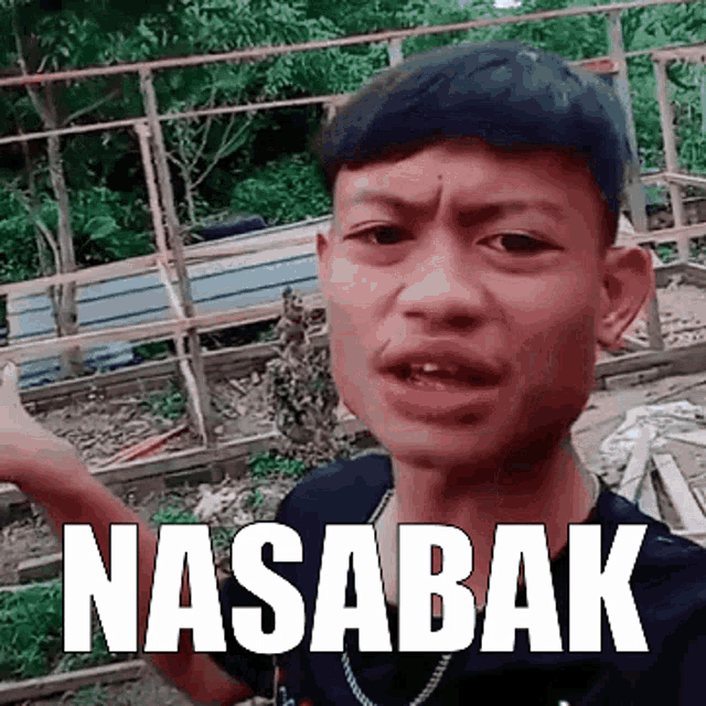 a young man is making a funny face with the words nasabak on his face .