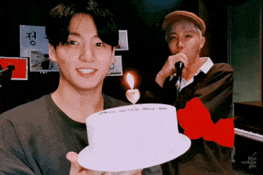 a man is holding a cake with a candle on it