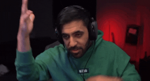 a man wearing headphones and a green sweatshirt that says mt40 on it