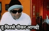 a man wearing sunglasses and a hat is sitting in a room with a foreign language .