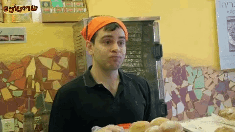a man wearing an orange headband is standing in front of a sign that says ' hebrew '