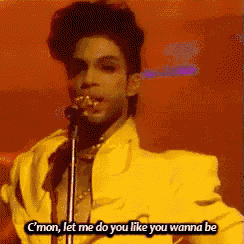 a man in a yellow jacket singing into a microphone with the words " c'mon let me do you like you wanna be " below him