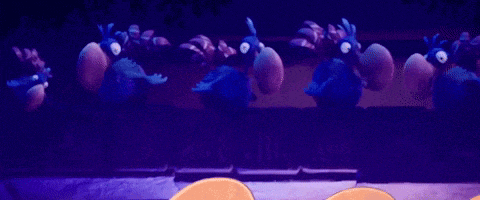 a group of blue birds are standing next to each other on a wall .
