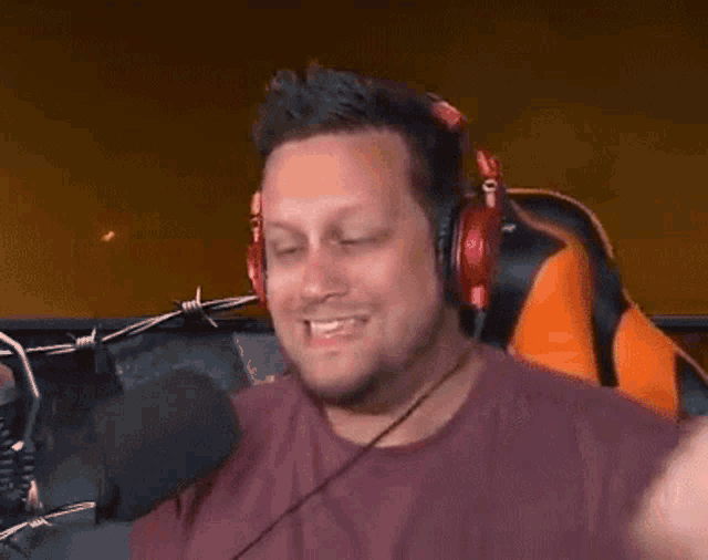 a man wearing headphones and a microphone is sitting in front of a microphone .