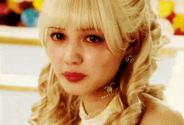 a close up of a woman 's face with blonde hair and red lips