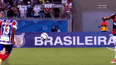 a soccer player with the number 13 on his back kicks the ball