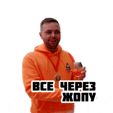 a man wearing an orange hoodie is holding a glass of wine and a medal around his neck that says " все через жопу "