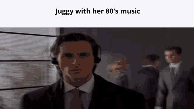 a man in a suit and tie is wearing headphones while standing in a room .