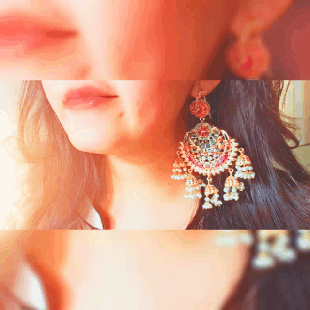 a woman wearing a pair of red and gold earrings with pearls