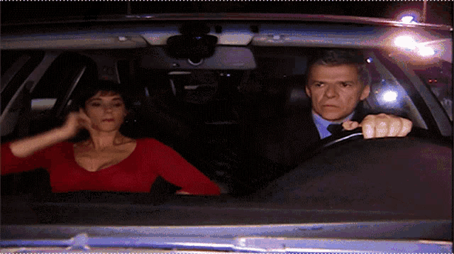 a man driving a car with a woman sitting in the back seat