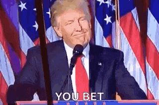 donald trump is giving a speech at a podium in front of an american flag while smiling .