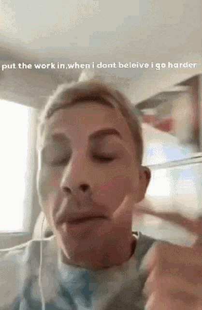 a man is wearing headphones and making a funny face while talking on a phone .