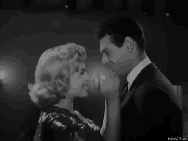 a black and white photo of a man and a woman dancing .