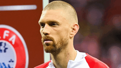 a man with a beard is standing in front of an uefa logo