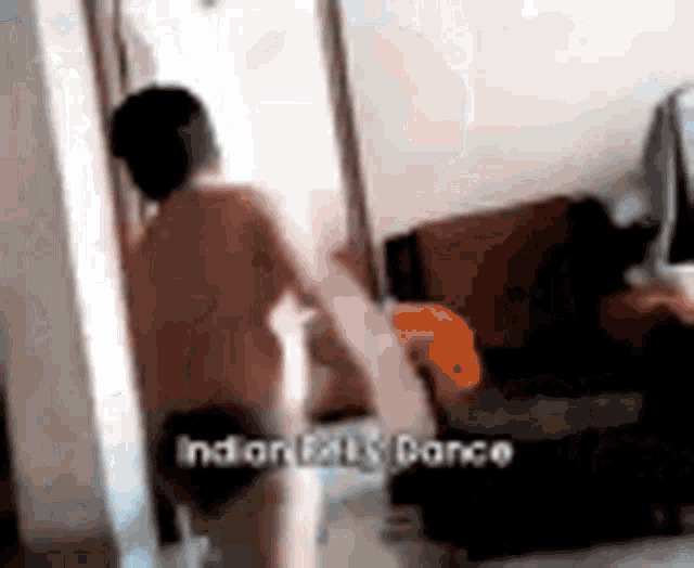 a shirtless man is standing in a living room with a couch .