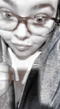 a close up of a person wearing glasses and ear buds