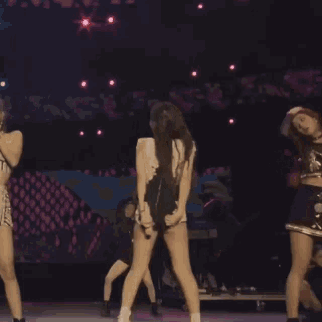 a group of women are dancing on a stage with a sign behind them that says " it 's a tiger "