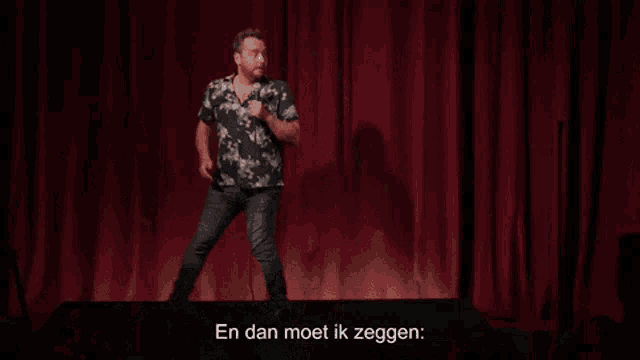 a man is standing on a stage holding a microphone and saying ga je boel zoeken misschien ?