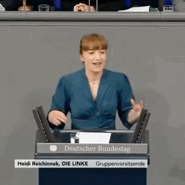 a woman is standing at a podium giving a speech in front of a microphone .