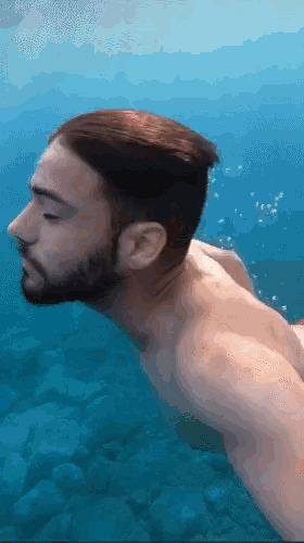 a man with a beard is swimming underwater