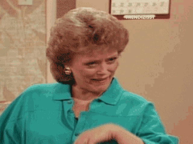 a woman in a green shirt is smiling in front of a calendar that says trendizisst on it