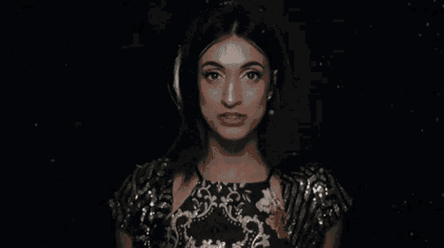 a woman is swimming in a dark pool of water .