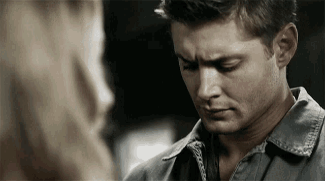 a close up of a man looking at a woman