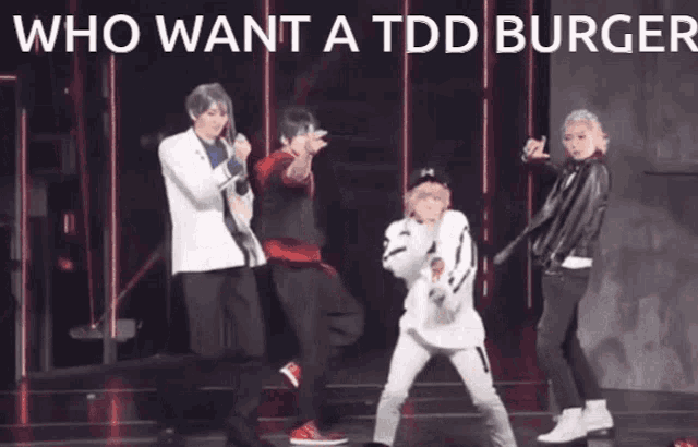 a group of people are dancing on a stage with the words who want a tdd burger above them