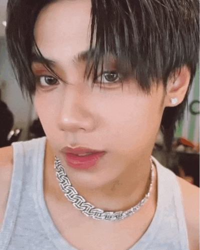a close up of a young man wearing a choker necklace