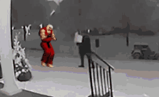 a man in red karate pants is standing on a snowy porch