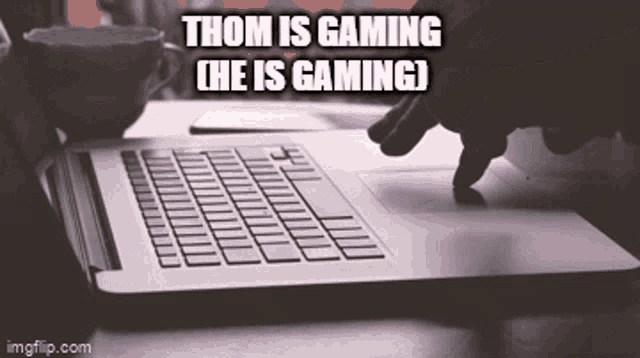 a person is typing on a laptop with the caption " thom is gaming "