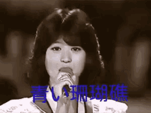a black and white photo of a woman singing into a microphone with chinese writing behind her