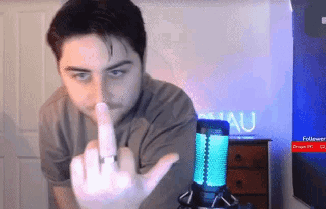 a man with a ring on his finger giving the middle finger