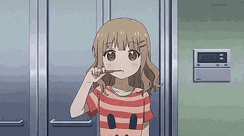 a girl brushing her teeth in front of a door