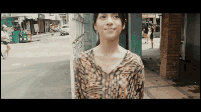 a woman in a leopard print shirt is standing in front of a store that says ' auto cash '
