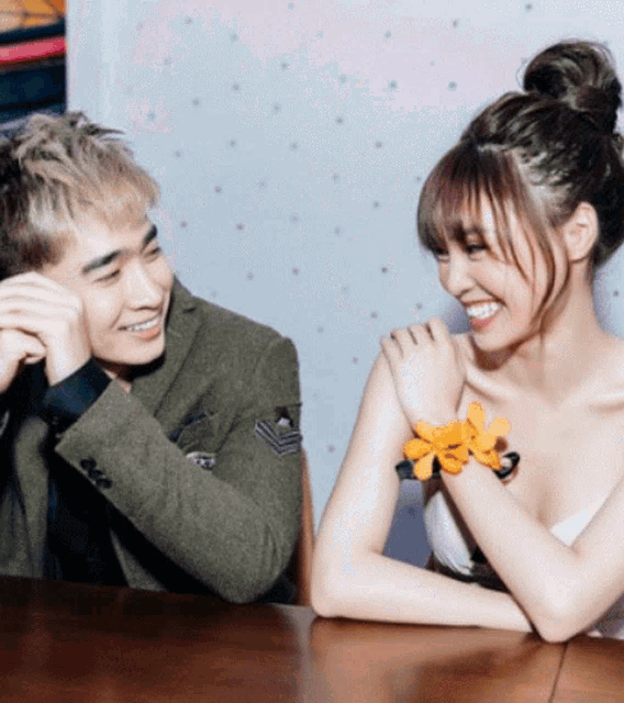 a man and a woman are sitting at a table laughing