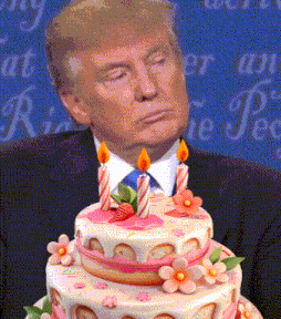 a man in a suit stands in front of a birthday cake