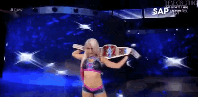 a woman in a wrestling outfit is holding a wrestling championship belt .