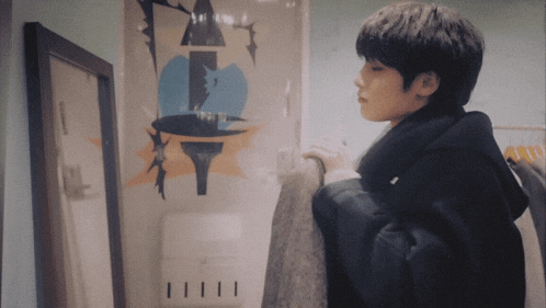 a person standing in front of a wall with a drawing on it