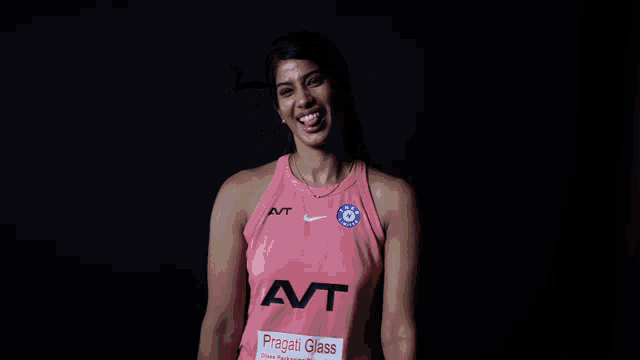 a woman wearing a pink tank top that says avt