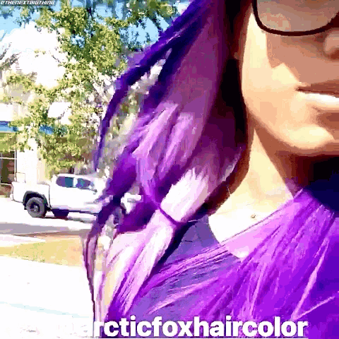 a woman with purple hair is wearing glasses and a shirt that says arctic foxhaircolor