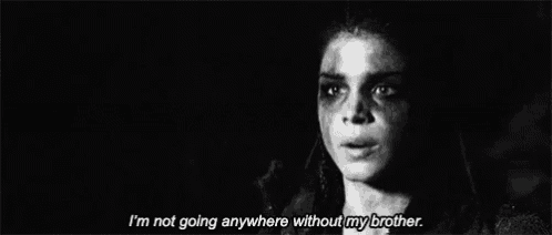 a black and white photo of a woman with blood on her face and the words `` i 'm not going anywhere without my brother ''