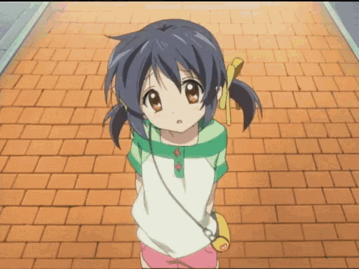 a little girl standing on a brick sidewalk looking up