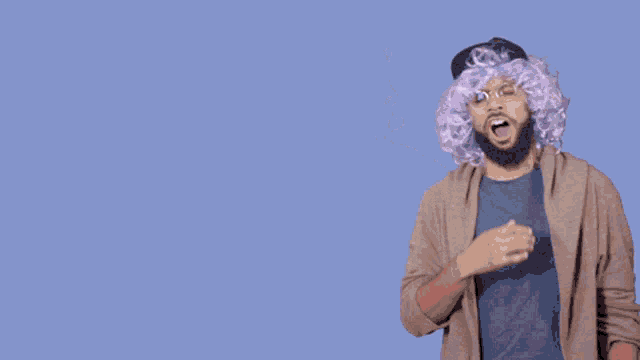 a man wearing a purple wig and a hat stands in front of a blue background that says mondays