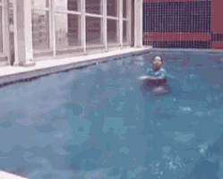 a person is swimming in a pool with a raft in their hand