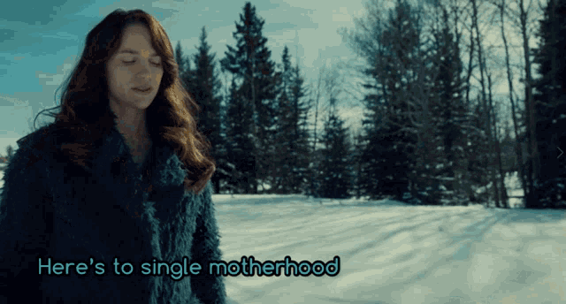 a woman standing in the snow with the words here 's to single motherhood written below her
