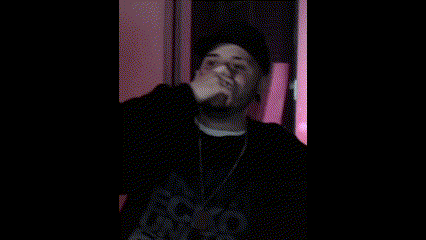 a man in a black hat is making a funny face while wearing a black shirt .