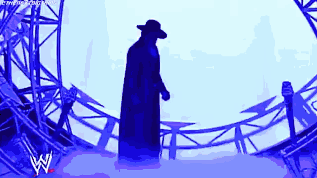 a silhouette of a man in a cowboy hat standing on a stage
