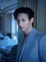 a man in a blue suit is standing in front of a mirror .